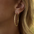 Dominique Cohen texture hoop gold earrings,<br>shown stacked with our diamond huggie hoops in white diamonds <span class='visuallyhidden'>Call, text 323-404-2959 for shopping help.</span>